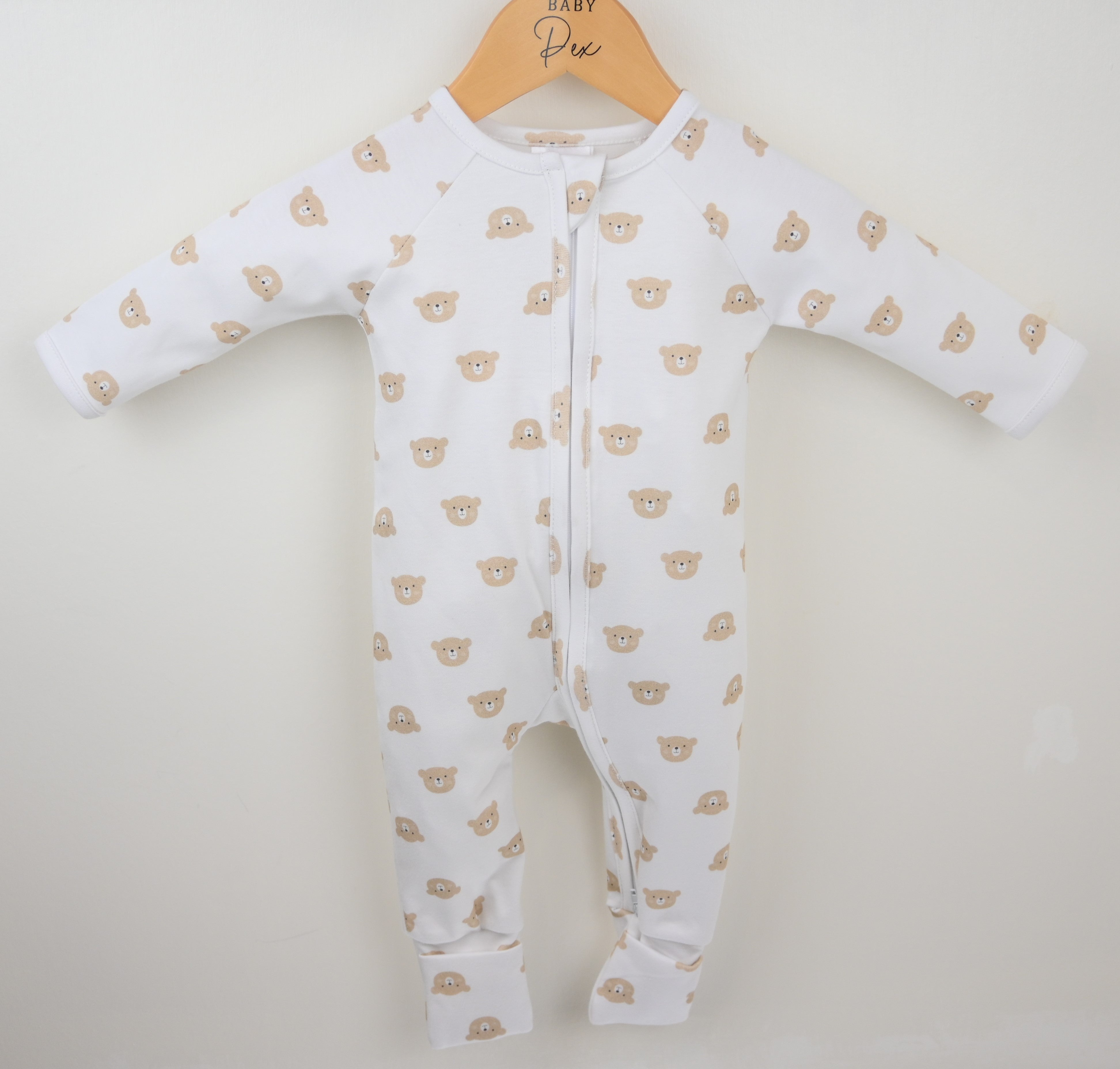 Baby onesie with bear pattern on a hanger against a white background