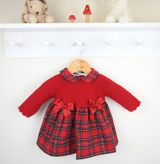 Red dress with plaid pattern on a hanger against a white background