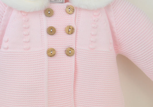 Pink baby coat with white fur collar on a neutral background